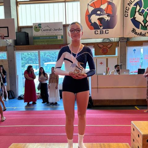 Une gymnaste sur le podium avec son trophée
