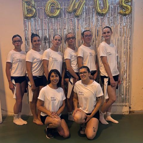 Le groupe de gymnastes et leurs entraîneuses en t-shirt blanc